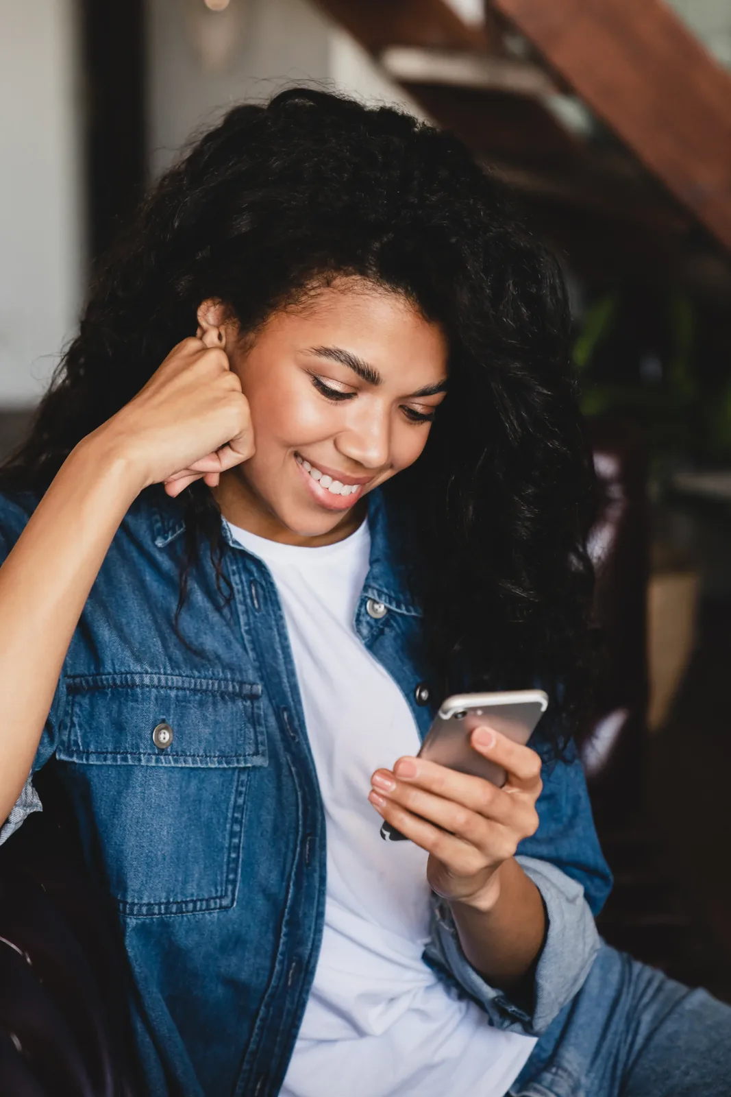 An adult smiling while using their phone